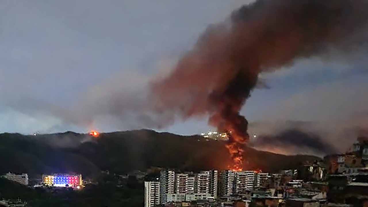 Incendio en Fuerte Tiuna, el mayor complejo militar de Venezuela, visto desde la distancia tras una serie de explosiones en Caracas el 3 de enero de 2026. El ejército estadounidense estuvo detrás de una serie de ataques contra la capital venezolana, Caracas, el sábado, según informaron medios estadounidenses. La Casa Blanca y el Pentágono no han comentado sobre las explosiones ni sobre los informes de aeronaves sobrevolando la ciudad. Los medios estadounidenses CBS News y Fox News informaron que funcionarios anónimos de la administración Trump confirmaron la participación de fuerzas estadounidenses. (Foto AFP) | Foto:afp