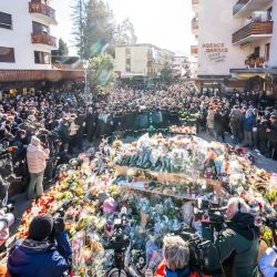 La gente se reúne alrededor de un monumento improvisado para presentar sus respetos depositando flores, velas y mensajes cerca del bar Constellation, en Crans-Montana, en honor a las víctimas del incendio que arrasó el local en la lujosa estación de esquí alpina la víspera de Año Nuevo. Las autoridades que investigan el incendio de Año Nuevo en la estación suiza de Crans-Montana han identificado a 24 de las 40 personas fallecidas, entre ellas 11 menores y seis extranjeros, según informó la policía. Además, 119 personas resultaron heridas durante el incendio, la mayoría de ellas de gravedad, según el último balance. | Foto:MAXIME SCHMID / AFP