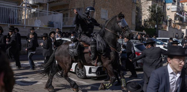 La policía montada israelí dispersa a judíos ultraortodoxos que protestaban contra el reclutamiento militar israelí frente a un centro de reclutamiento militar en Jerusalén.