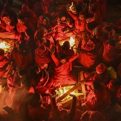Devotos hindúes se calientan alrededor de hogueras antes de darse un baño sagrado en el río Shali con motivo del festival Swasthani Brata Katha en las afueras de Katmandú, Nepal. | Foto:PRAKASH MATHEMA / AFP