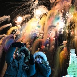 La gente disfruta de los fuegos artificiales durante la ceremonia inaugural del 42.º Festival Internacional de Hielo y Nieve de Harbin, China, en Harbin, provincia de Heilongjiang, noreste de China. | Foto:JADE GAO / AFP