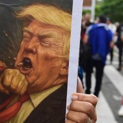 Un cartel que representa al héroe de la independencia de Colombia y Venezuela, Simón Bolívar, golpeando al presidente estadounidense Donald Trump, durante la Marcha por la Soberanía y la Democracia en Medellín, Colombia. El presidente colombiano Gustavo Petro se declaró dispuesto a "tomar las armas" ante las amenazas de su homólogo estadounidense, Donald Trump, quien el fin de semana capturó al líder de la vecina Venezuela en un ataque militar. | Foto:JAIME SALDARRIAGA / AFP