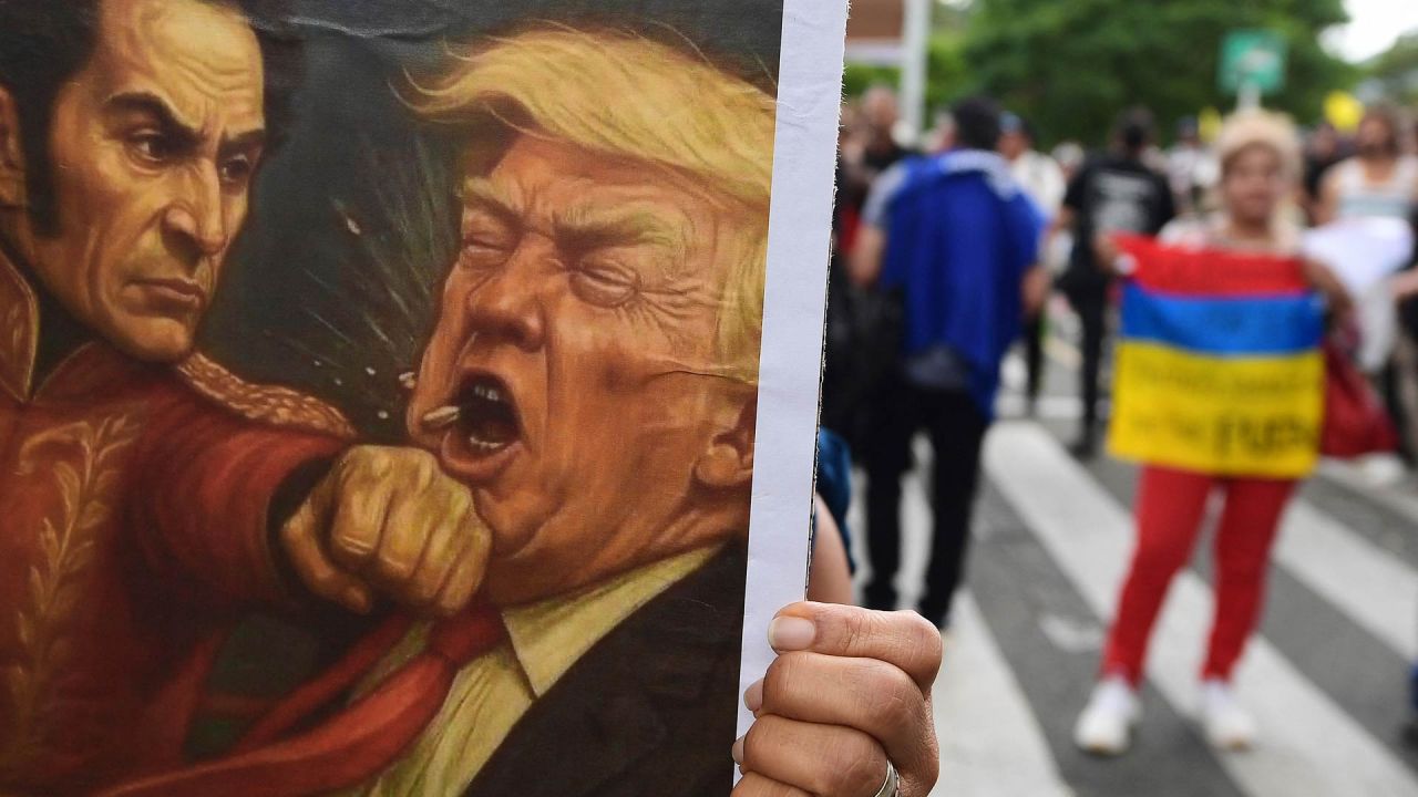 Un cartel que representa al héroe de la independencia de Colombia y Venezuela, Simón Bolívar, golpeando al presidente estadounidense Donald Trump, durante la Marcha por la Soberanía y la Democracia en Medellín, Colombia. El presidente colombiano Gustavo Petro se declaró dispuesto a "tomar las armas" ante las amenazas de su homólogo estadounidense, Donald Trump, quien el fin de semana capturó al líder de la vecina Venezuela en un ataque militar. | Foto:JAIME SALDARRIAGA / AFP
