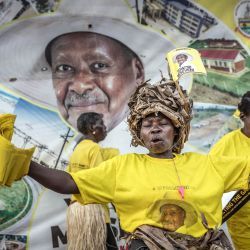 Efrance Nsudde, de 50 años, hace campaña para el actual presidente de Uganda y candidato presidencial del Movimiento de Resistencia Nacional (MRN), Yoweri Museveni, mientras baila con banderas del partido en una concurrida rotonda, antes de las elecciones generales ugandesas de 2026, en Kampala. | Foto:LUIS TATO / AFP