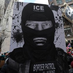 Una persona sostiene un cartel mientras participa en una protesta organizada por Rise and Resist contra las actividades del Servicio de Inmigración y Control de Aduanas (ICE) de Estados Unidos y la intervención estadounidense en Venezuela en Nueva York. | Foto:TIMOTHY A. CLARY / AFP