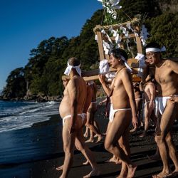 Participantes portan un santuario portátil (mikoshi) durante el festival de purificación marina de invierno, un evento anual de Año Nuevo, en una playa de Numazu, prefectura de Shizuoka. | Foto:Philip Fong / AFP