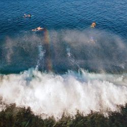 Una vista aérea muestra a surfistas surfeando una ola en la playa de Lhoknga, provincia indonesia de Aceh. | Foto:CHAIDEER MAHYUDDIN / AFP