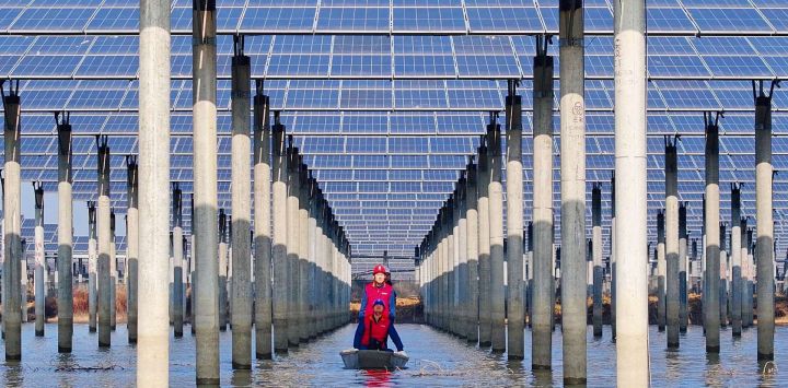 Los trabajadores revisan los paneles solares instalados en un lago en Tianchang, provincia de Anhui, este de China.
