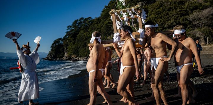 Participantes portan un santuario portátil (mikoshi) durante el festival de purificación marina de invierno, un evento anual de Año Nuevo, en una playa de Numazu, prefectura de Shizuoka.