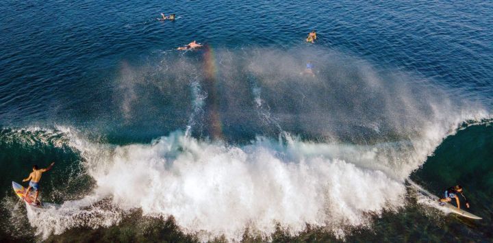 Una vista aérea muestra a surfistas surfeando una ola en la playa de Lhoknga, provincia indonesia de Aceh.