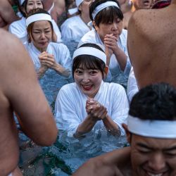 Los participantes se bañan en agua fría para purificar sus almas y cuerpos durante un ritual de Año Nuevo en el Santuario Teppozu Inari en Tokio. | Foto:Philip Fong / AFP