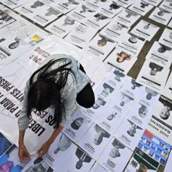 Una mujer participa en una manifestación publicando el retrato de un preso político en la Universidad Central de Venezuela en Caracas. Venezuela anunció la liberación de decenas de presos políticos, mientras organizaciones de derechos humanos cuestionaban las cifras y sus familiares exigían liberaciones más rápidas tras el derrocamiento del autócrata Nicolás Maduro por parte de las fuerzas militares estadounidenses. | Foto:JUAN BARRETO / AFP