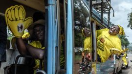 Partidarios del actual presidente de Uganda y candidato presidencial del Movimiento de Resistencia Nacional (MRN), Yoweri Museveni, corean consignas desde un autobús mientras se dirigen al lugar de la manifestación antes del mitin de cierre de campaña del partido para las elecciones generales ugandesas de 2026, en Kampala.
