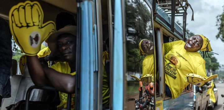 Partidarios del actual presidente de Uganda y candidato presidencial del Movimiento de Resistencia Nacional (MRN), Yoweri Museveni, corean consignas desde un autobús mientras se dirigen al lugar de la manifestación antes del mitin de cierre de campaña del partido para las elecciones generales ugandesas de 2026, en Kampala.