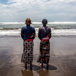 Los asistentes del palacio, conocidos como abdi dalem, rezan durante el ritual 'Labuhan Laut' del Palacio de Yogyakarta, expresando gratitud por las bendiciones del mar arrojando ofrendas al océano en la playa Parangkusumo en Bantul, Yogyakarta, Indonesia. | Foto:DEVI RAHMAN / AFP