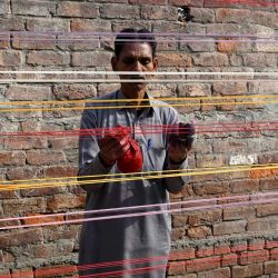 Un hombre aplica capas de polvo de vidrio a las cuerdas de una cometa antes del Festival de Basant en Lahore, Pakistán. | Foto:Arif Ali / AFP