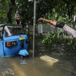 Un joven se sumerge en las aguas de la inundación después de que las fuertes lluvias dejaran zonas residenciales parcialmente sumergidas en Yakarta, Indonesia. | Foto:AFP