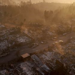Vista aérea de los restos calcinados de viviendas destruidas al atardecer tras un incendio forestal en Concepción, Chile. Incendios forestales descontrolados arrasaron comunidades del sur de Chile, dejando ruinas calcinadas y al menos 19 muertos, informaron las autoridades. | Foto:RAUL BRAVO / AFP