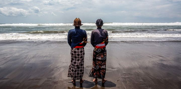 Los asistentes del palacio, conocidos como abdi dalem, rezan durante el ritual 'Labuhan Laut' del Palacio de Yogyakarta, expresando gratitud por las bendiciones del mar arrojando ofrendas al océano en la playa Parangkusumo en Bantul, Yogyakarta, Indonesia.