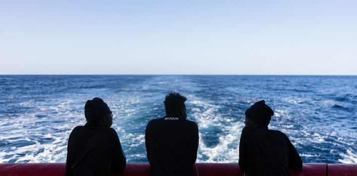 Migrantes en la cubierta de popa del barco de rescate "Ocean Viking", operado por la ONG SOS Mediterranee, mientras navega hacia una zona de socorro en aguas internacionales frente a la costa de Libia.