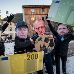 Manifestantes con máscaras del CEO de Tesla, Elon Musk; el canciller alemán, Friedrich Merz; y el vicepresidente estadounidense, J. D. Vance, sostienen recortes de cartón de billetes de euro mientras participan en una manifestación contra el Foro Económico Mundial (FEM) en vísperas de su reunión anual en Davos. | Foto:FABRICE COFFRINI / AFP