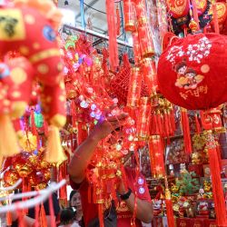 Personas eligen decoraciones para el Año Nuevo chino en un puesto callejero en Glodok el barrio chino, en Yakarta, Indonesia. | Foto:Xinhua/Agung Kuncahya B.