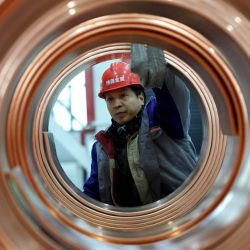 Un trabajador prepara productos de varillas de cobre para transporte en el taller de una empresa en Huai'an, en la provincia de Jiangsu, en el este de China. | Foto:Xinhua/Yin Chao