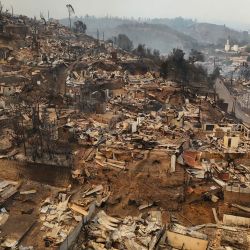 Vista aérea de los restos calcinados de viviendas destruidas tras un incendio forestal en Concepción, Chile. El presidente chileno Gabriel Boric declaró el estado de emergencia en dos regiones del sur, donde los devastadores incendios forestales han obligado a unas 20.000 personas a evacuar sus hogares. | Foto:RAUL BRAVO / AFP