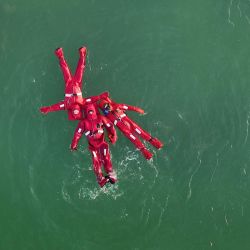 Vista aérea tomada con un dron de personas disfrazadas de cangrejos de río flotando en el agua en un parque, en Yinchuan, en la región autónoma hui de Ningxia, en el noroeste de China. | Foto:Xinhua/Wang Peng