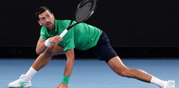 El serbio Novak Djokovic devuelve la pelota al español Pedro Martínez durante su partido individual masculino en el segundo día del Abierto de Australia en Melbourne.
