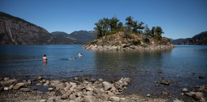 Imagen de personas nadando en la playa "La Islita" del Lago Lolog, a 12 kilómetros de la ciudad de San Martín de los Andes, Argentina.