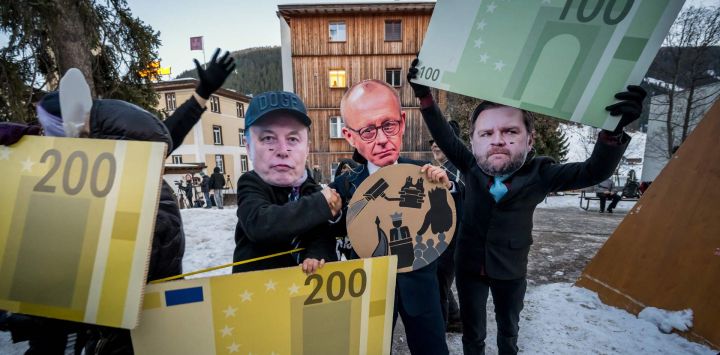 Manifestantes con máscaras del CEO de Tesla, Elon Musk; el canciller alemán, Friedrich Merz; y el vicepresidente estadounidense, J. D. Vance, sostienen recortes de cartón de billetes de euro mientras participan en una manifestación contra el Foro Económico Mundial (FEM) en vísperas de su reunión anual en Davos.