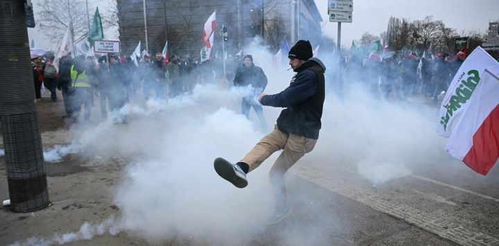Un manifestante devuelve un bote de gas lacrimógeno durante los enfrentamientos con la policía frente al Parlamento Europeo durante una protesta contra el acuerdo de libre comercio entre la Unión Europea y los países del Mercosur, en vísperas de la votación sobre su remisión a los tribunales, en Estrasburgo, Francia.