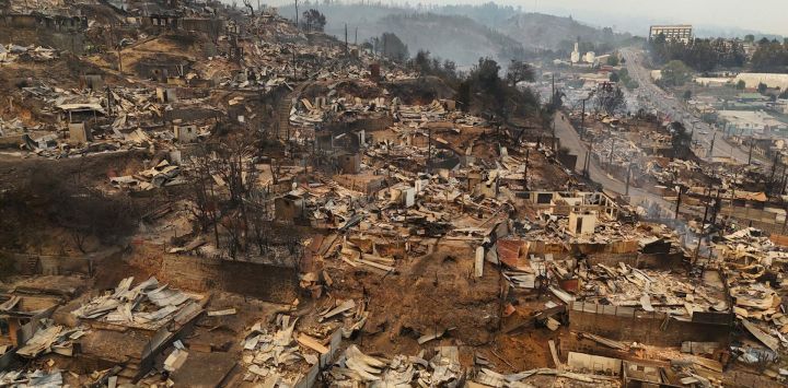 Vista aérea de los restos calcinados de viviendas destruidas tras un incendio forestal en Concepción, Chile. El presidente chileno Gabriel Boric declaró el estado de emergencia en dos regiones del sur, donde los devastadores incendios forestales han obligado a unas 20.000 personas a evacuar sus hogares.
