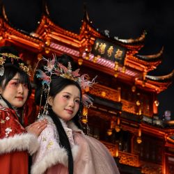 Mujeres con trajes tradicionales posan para fotografías en el Jardín Yu de Shanghái, China. | Foto:Hector Retamal / AFP
