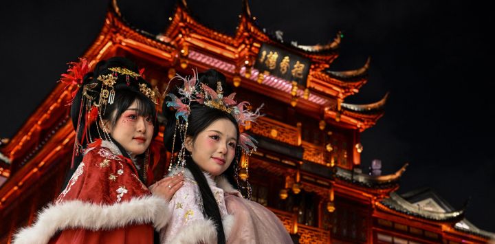 Mujeres con trajes tradicionales posan para fotografías en el Jardín Yu de Shanghái, China.