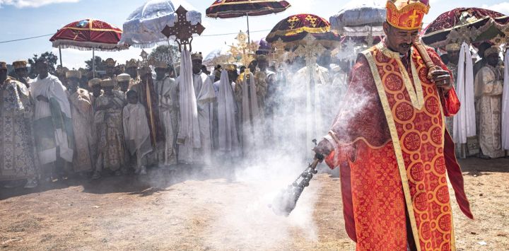 Un clérigo ortodoxo de alto rango agita un incensario para esparcir incienso entre los fieles antes de la procesión durante la liturgia de Timkat, en Jan Meda, Adís Abeba, Etiopía.