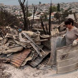 Personas realizan trabajos de limpieza de casas destruidas después de un incendio forestal, en la comuna de Penco, en la región del Biobío, Chile. | Foto:Xinhua/Str