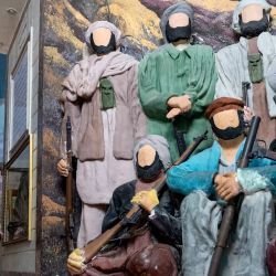Esta fotografía muestra a un visitante afgano sentado junto a un diorama con figuras de combatientes muyahidines, pintadas con yeso para censurar el Manzar-e-Jahad, o Museo de la Yihad, que conmemora la resistencia afgana a la invasión soviética de 1979, en Herat. | Foto:WAKIL KOHSAR / AFP