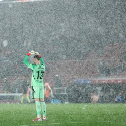 El arquero del Real Oviedo, Aaron Escandell Banacloche, intenta protegerse con las manos de una fuerte tormenta de granizo durante el partido de fútbol de la liga española entre el FC Barcelona y el Real Oviedo en el Estadio Camp Nou en Barcelona. | Foto:Josep Lago / AFP