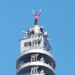 El escalador estadounidense Alex Honnold levanta los brazos desde lo alto del edificio Taipei 101 tras escalar con éxito en solo integral el emblemático rascacielos sin cuerdas ni equipo de seguridad en Taipéi, Taiwán. | Foto:I-Hwa Cheng / AFP
