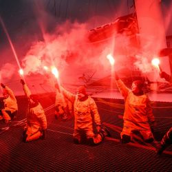 La capitana francesa Alexia Barrier y sus tripulantes celebran con bengalas encendidas su llegada al puerto de Brest a bordo del multicasco Ultim Idec Sport tras cruzar la meta del Trofeo Julio Verne, frente a la costa de Brest, Bretaña. | Foto:LOIC VENANCE / AFP