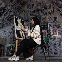 Marah Al-Za'anin, una joven desplazada de dieciocho años, pinta un retrato que cuelga dentro de su tienda de campaña en el albergue escolar Al-Rimal, gestionado por el Organismo de Obras Públicas y Socorro de las Naciones Unidas para los Refugiados de Palestina en Oriente Próximo (OOPS), en el norte de la Franja de Gaza. Desde el 10 de octubre, una frágil tregua en Gaza, patrocinada por Estados Unidos, ha frenado en gran medida los combates entre las fuerzas israelíes y Hamás, pero ambas partes han denunciado frecuentes violaciones. | Foto:OMAR AL-QATTAA / AFP