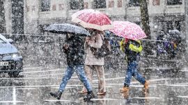 Personas caminan bajo la nevada, en Madrid, España.