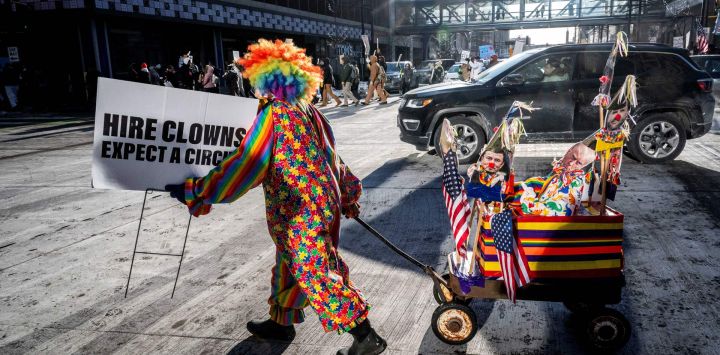 Coleen Fitzgerald, una trabajadora de la construcción jubilada de 73 años que protestó contra la guerra de Vietnam hace décadas, tira de una carreta con marionetas que representan a miembros de la administración actual mientras se une a otros manifestantes durante una marcha por las calles del centro de Minneapolis, Minnesota.