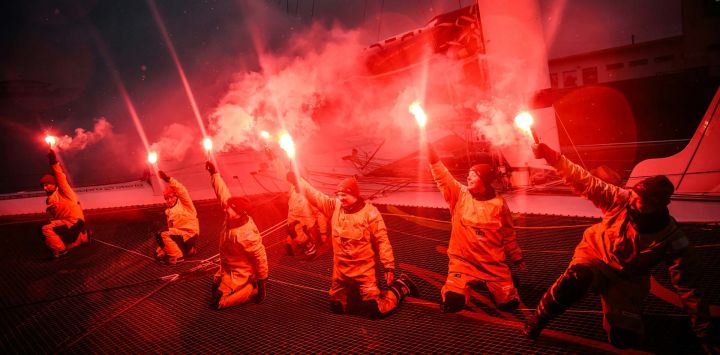 La capitana francesa Alexia Barrier y sus tripulantes celebran con bengalas encendidas su llegada al puerto de Brest a bordo del multicasco Ultim Idec Sport tras cruzar la meta del Trofeo Julio Verne, frente a la costa de Brest, Bretaña.