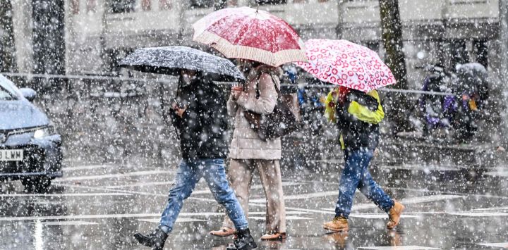 Personas caminan bajo la nevada, en Madrid, España.