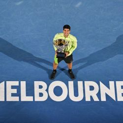 El español Carlos Alcaraz celebra con la Norman Brookes Challenge Cup tras ganar la final individual masculina contra el serbio Novak Djokovic en el día quince del torneo de tenis Abierto de Australia en Melbourne. | Foto:Paul Crock / AFP