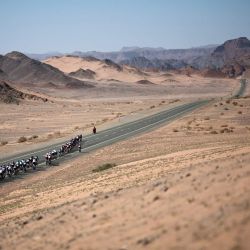 El pelotón pedalea durante la quinta y última etapa del AlUla Tour, una carrera ciclista de 163,9 km desde el casco antiguo de Alula hasta Skyviews of Harrat Uwayrid. | Foto:ANNE-CHRISTINE POUJOULAT / AFP
