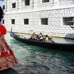 Imagen de un juerguista posando con una góndola cerca del Gran Canal durante el Carnaval de Venecia 2026, en Venecia, Italia. | Foto:Xinhua/Alberto Lingria
